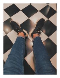 Low section of man standing on tiled floor