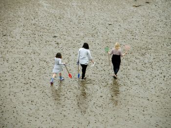 High angle view of women and girl walking at beach