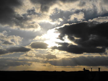 Silhouette of landscape against cloudy sky