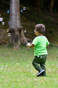 Rear view of boy playing with bubbles