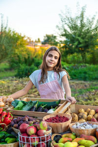 Portrait of smiling woman picking fruits for sale at market