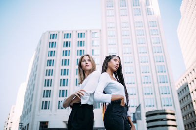 Full length of woman standing against buildings in city