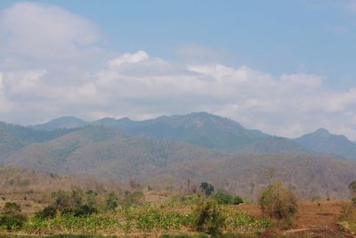 Scenic view of mountains against cloudy sky