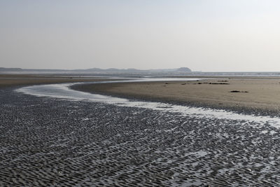 Surface level of beach against clear sky