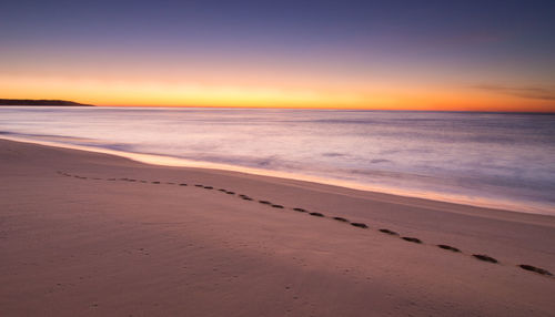 Scenic view of beach against sky during sunset