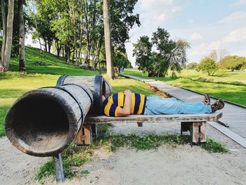 Side view of man lying on bench in park