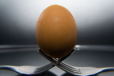 Close-up of egg balanced on forks