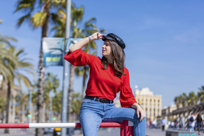 Smiling teenage girl wearing red top in city during sunny day