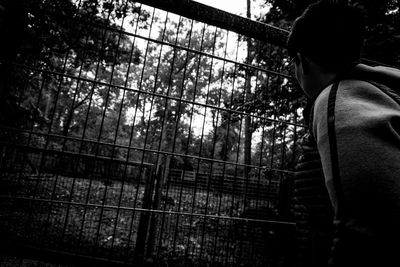 Rear view of man standing by railing