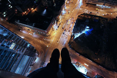 Low section of people standing on illuminated city at night