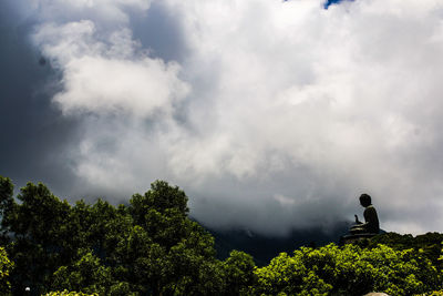 Low angle view of silhouette trees against sky