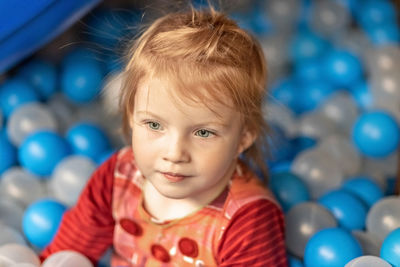 Portrait of a little toddler girl with red hair in a ballroom.