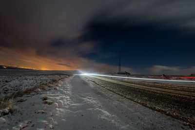Road against sky at night during winter