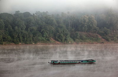 Ferry boat in river during foggy weather