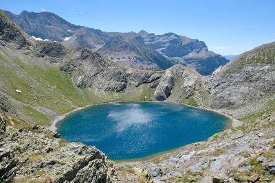 Scenic view of lake and mountains against blue sky