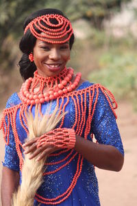 Portrait of smiling woman in traditional clothing holding fur outdoors