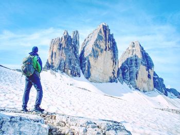 Backpacker on trip around tre cime di lavaredo in sunny april morning. view from tour at massive