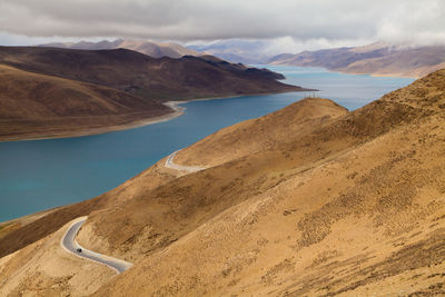 Scenic view of lake by mountains against sky