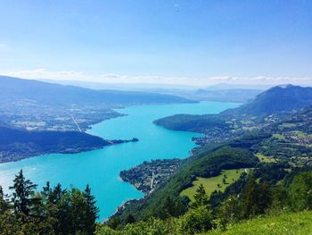 Scenic view of sea and mountains against blue sky