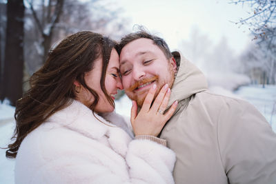 Loving couple on a snowy winter field. happy together.