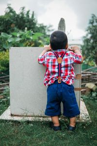 Rear view of boy standing on field