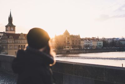 Rear view of man standing against buildings in city