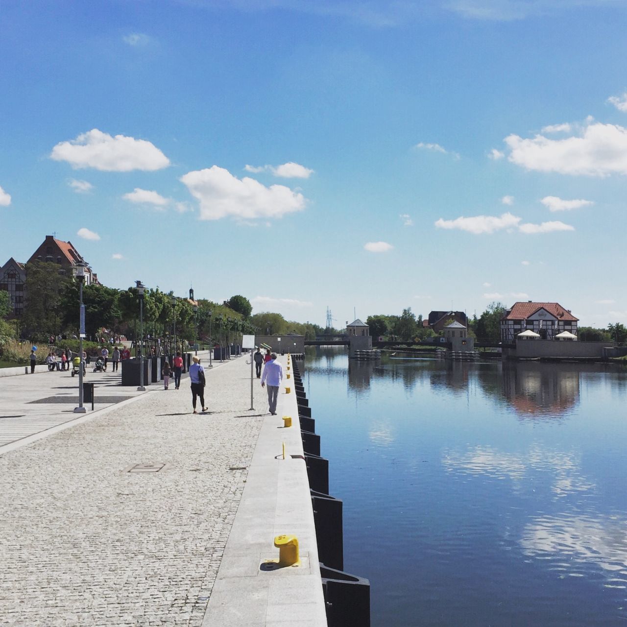 water, sky, built structure, architecture, building exterior, blue, cloud, cloud - sky, reflection, day, tree, person, incidental people, men, outdoors, pier, lake, river, lifestyles