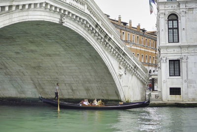 People on boats in canal along buildings