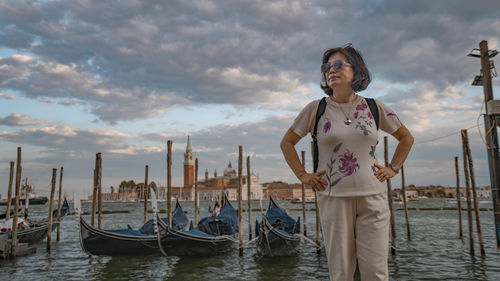 Portrait of young woman standing in boat in sea