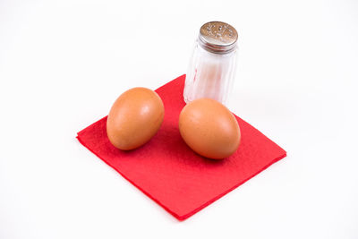 Close-up of fruits in glass jar on white background