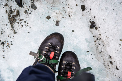 Low section of man standing on snow