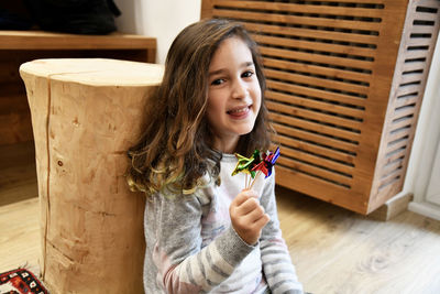Portrait of smiling girl with pinwheel toys at home