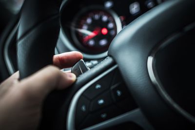 Cropped hand of woman driving car