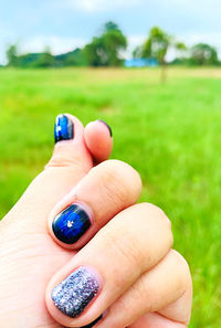 Close-up of human hand holding grass