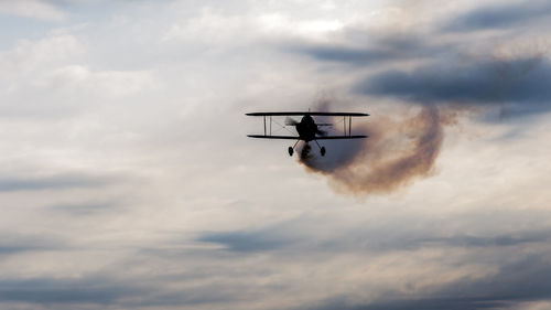 Low angle view of airplane flying against sky