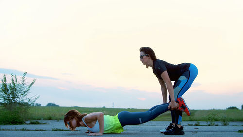 Beautiful, athletic, young women in sunglasses, in tights, perform synchronously strength exercises