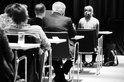 Rear view of businesspeople sitting in seminar