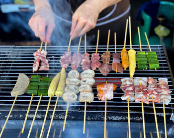 Person preparing food on barbecue grill