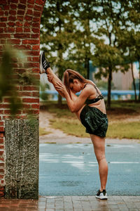 Young woman exercising outdoors in park.