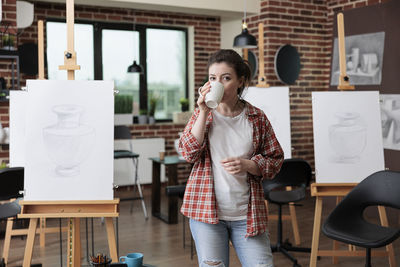 Woman drinking coffee in classroom