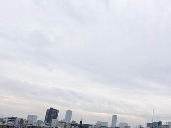 High section of modern buildings against cloudy sky