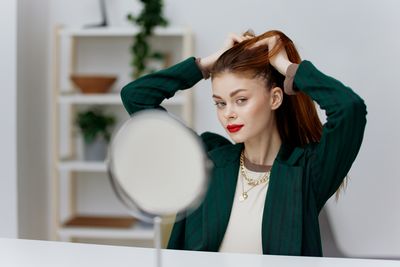 Side view of young woman using laptop at home