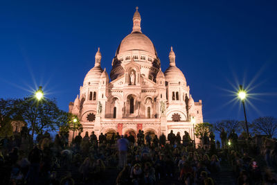 Crowd outside cathedral against night sky