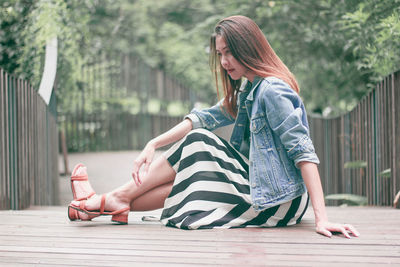 Full length of woman sitting outdoors