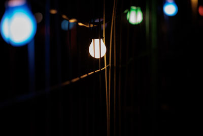 Close-up of illuminated light bulb at night