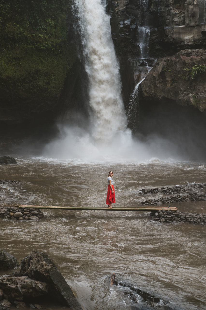 water, scenics - nature, long exposure, motion, waterfall, beauty in nature, flowing water, real people, women, one person, nature, blurred motion, leisure activity, red, river, rock, lifestyles, adult, power in nature, flowing, outdoors