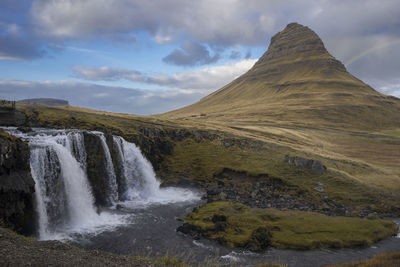 Scenic view of waterfall against sky