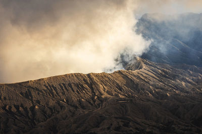 Smoke emitting from volcanic mountain against sky