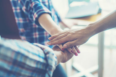 Midsection of people stacking hands while showing unity 