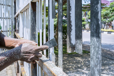 Midsection of man working on railing